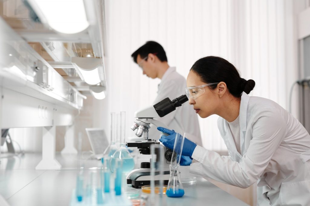 Lab Technician Looking through Microscope