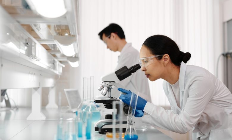 Lab Technician Looking through Microscope